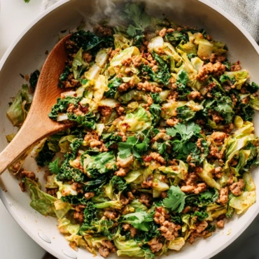 Top-down view of ground turkey and cabbage stir-fry in a white skillet