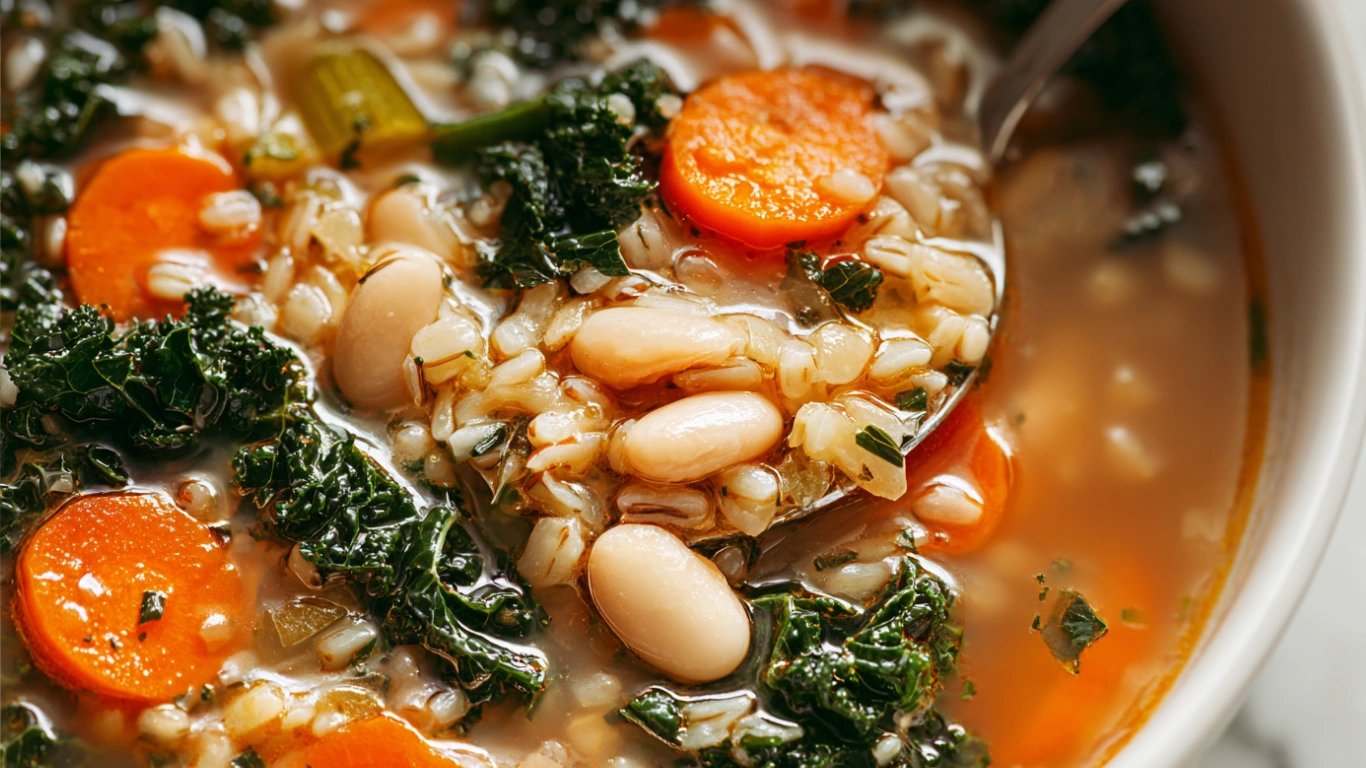 Sardinian longevity soup served in a modern white bowl with beans, barley, vegetables, and herbs in bright natural light.
