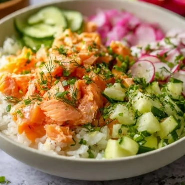 Easy salmon rice bowl topped with fresh veggies and sesame seeds