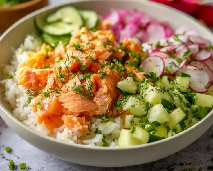 Easy salmon rice bowl topped with fresh veggies and sesame seeds