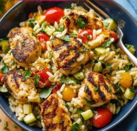 Mediterranean Chicken and Rice Bowl topped with fresh herbs and vegetables