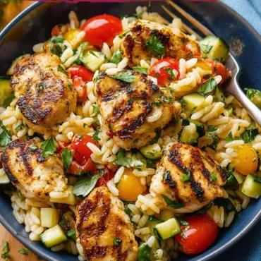 Mediterranean Chicken and Rice Bowl topped with fresh herbs and vegetables