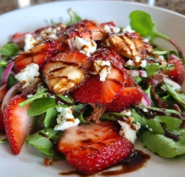 Fresh strawberry feta salad with mixed greens and walnuts on a plate