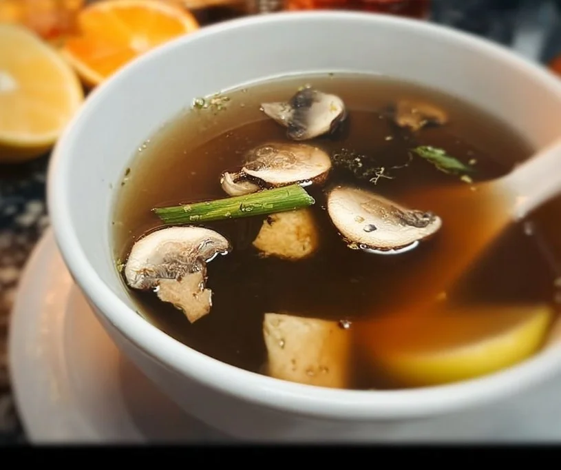 Bowl of Japanese clear soup with vegetables and herbs
