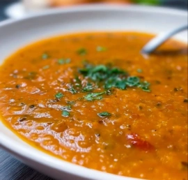 Bowl of easy spicy Tomato Lentil Soup with fresh herbs