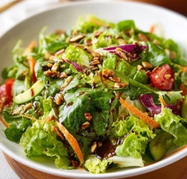 Simple mixed greens salad topped with balsamic vinaigrette dressing